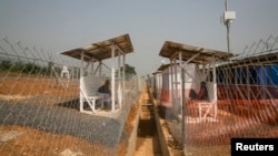 An Ebola patient, who only provided his first name as Peter, right, talks to his wife from within the quarantined zone in the Kerry town Ebola treatment center outside Freetown, Sierra Leone, Dec. 22, 2014. 