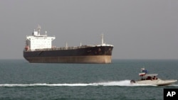 FILE - An Iranian Revolutionary Guard speedboat passes near an oil tanker, July 2, 2012. A collision late Saturday off the eastern coast of China left 30 Iranians missing.