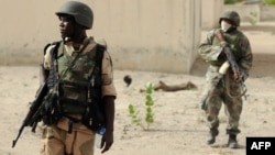 FILE - Nigerian soldiers are seen on patrol near a Boko Haram camp in the north of Borno state.
