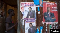 A boy enters an house with various campaign posters at the Kangemi slum in Kenya's capital Nairobi, February 28, 2013. 