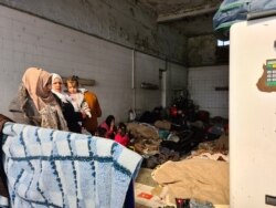 FILE - Refugees take shelter in a gas station in the Turkish country side, saying they want to cross the closed Greek border and do not want to be taken to Istanbul, were they could be homeless and potentially exposed to coronavirus, March 18, 2020.