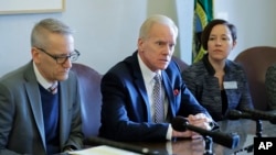 State Rep. Paul Harris R-Vancouver, center, talks to reporters, Feb. 8, 2019, following a public hearing at the Capitol in Olympia, Wash., on a bill that would remove parents' ability to to opt school-age children out of the combined measles, mumps and rubella vaccine. 