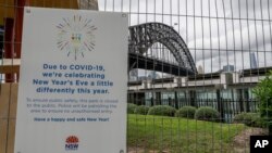 A signs adorns a security fence near the harbor foreshore ahead of New Year's Eve in Sydney, Australia, Dec. 31, 2020.