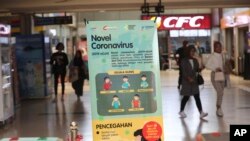 A worker wearing protective gear sprays disinfectant as a precaution against the new coronavirus in an eyeglass shop at a department store in Seoul, South Korea, Monday, March 2, 2020.