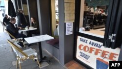 FILE - Customers eat in a cafe after more than seven weeks of coronavirus restrictions, in Sydney, Australia, May 15, 2020.