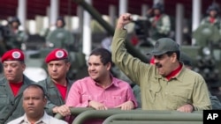 FILE - Nicolas Maduro Jr., center, accompanies his father, Venezuela's President Nicolas Maduro, in a military parade, in Caracas, Venezuela, April 13, 2018.