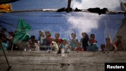 Children are seen through a fabric sheet as they watch the funeral of Palestinian boy Majdi al-Satri, who was killed by Israeli troops during a protest at the Israel-Gaza border, in Rafah in the southern Gaza Strip, July 28, 2018. 
