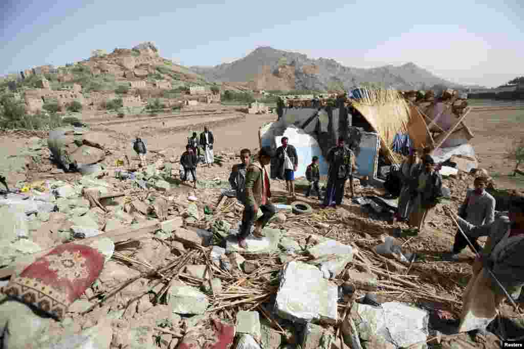 People gather around the wreckage of a house destroyed by an airstrike that killed three women and three children from one family, in the Bait Rejal village, west Sana&#39;a, April 7, 2015.