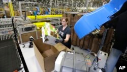 FILE - A worker places an item in a box for shipment,at a Amazon.com fulfillment center in DuPont, Washington. Amazon started “Lighting Deals” on Nov. 28, 2015 to roll out Cyber Monday.
