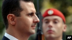 FILE - Syrian President Bashar Assad reviews the presidential guard during the welcoming ceremony in Athens, Dec. 15, 2003.