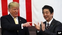 U.S. President Donald Trump, left, and Japan's Prime Minister Shinzo Abe react during delivering a speech to Japanese and U.S. troops as they aboard Japan Maritime Self-Defense Force's (JMSDF) helicopter carrier DDH-184 Kaga at JMSDF Yokosuka base in Yokosuka,Tuesday, May 28,2019