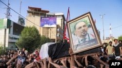 People chant slogans as they march with the body of renowned Iraqi anti-government activist Ihab al-Wazni (Ehab al-Ouazni) during a funerary procession in the central holy shrine city of Karbala on May 9, 2021.