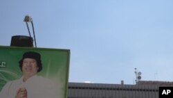 In this photo taken on a government-organized tour, a billboard depicting Libyan leader Moammar Gadhafi stands at the entrance to the international airport in Tripoli, Libya, Saturday, Aug. 20, 2011.