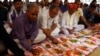 FILE - Indian businessmen write religious verses on their record-keeping books as part of a ritual to worship the Hindu deity of wealth in the western Indian city of Ahmedabad, Nov. 3, 2013. Hindu groups oppose a Sharia-compliant international bank's plan to operate in India.