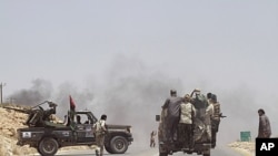 Rebel fighters enter the village of Al-Qawalish after a battle to seize control of the town from forces loyal to Libya's leader Moammar Gadhafi, July 6, 2011