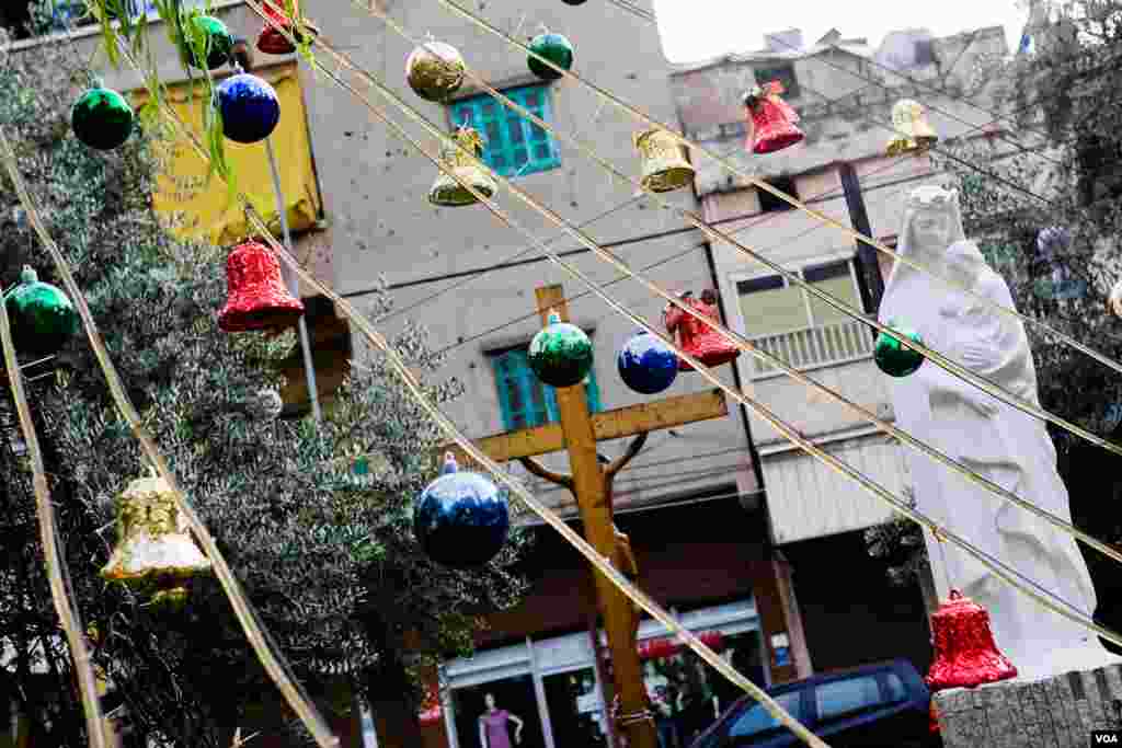 In Beirut&#39;s Armenian quarter, Christmas balls and bells near a statue of the Virgin Mary and Baby Jesus, Lebanon, December 2012. (VOA/V.Undritz) 