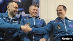 International Space Station (ISS) crew members Russian cosmonauts Evgeny Tarelkin (L) and Oleg Novitskiy (C) and U.S. astronaut Kevin Ford sit together at Kustanay Airport after they landed near the town of Arkalyk, March 16, 2013. 