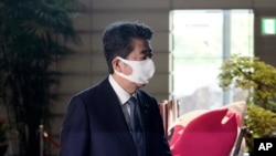 Japan's Prime Minister Shinzo Abe walks at the prime minister's office in Tokyo, Aug. 28, 2020. 