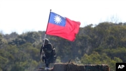 FILE - A soldier holds a Taiwanese flag during a military exercise aimed at repelling an attack from China, Jan. 19, 2021, in Hsinchu County, northern Taiwan.