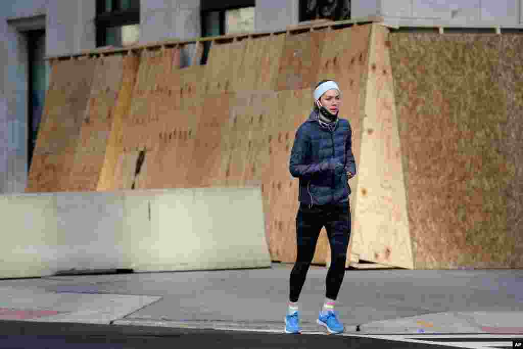 Un ciudadano hace ejercicio por el centro de la ciudad, entre notables medidas de seguridad. 16 de enero de 2021.