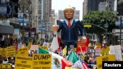 FILE - People march with an inflatable effigy of Republican presidential candidate Donald Trump during an immigrant rights May Day rally in Los Angeles, California, May 1, 2016. 