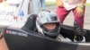 Sunny Wong in the PS Racing car, with Child Fund decals behind, Sept. 15, 2013.