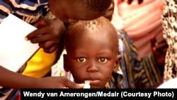 FILE - A child takes a dose of oral cholera vaccine at UNMISS Tomping camp in Juba. 