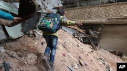 A child navigates rubble and barbed wire in Aleppo, Syria, Feb. 11, 2016.