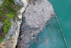 In this April 23, 2019, aerial photo, plastic bottles and other garbage float in river Drina near Visegrad, eastern Bosnia-Herzegovina.