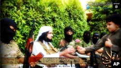 FILE - Screengrab from Islamic State-linked Twitter account purports to show senior military commander Abu Wahib handing a flower to a child while visiting southern Iraq, Sept. 20, 2014.