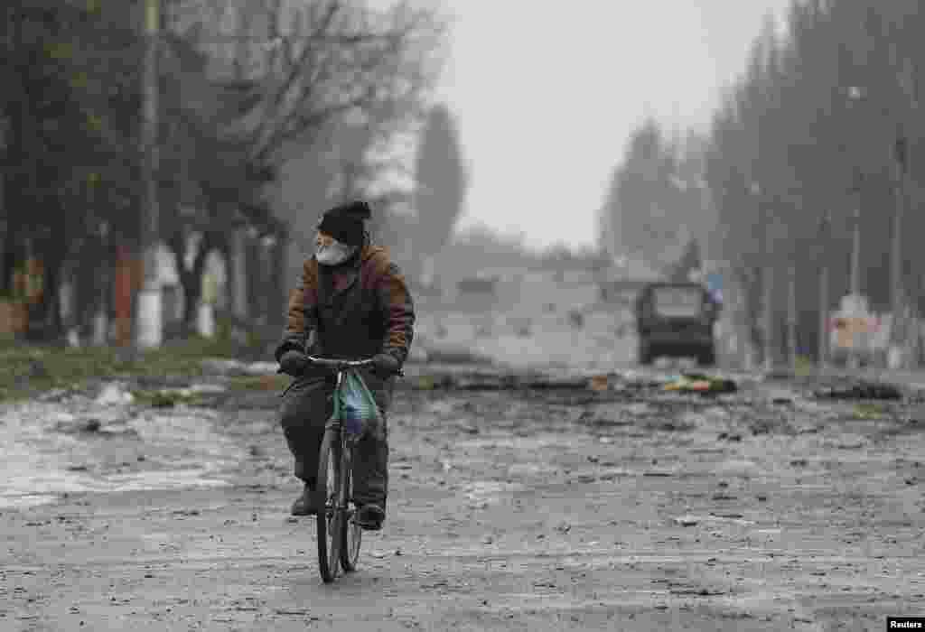 A local resident rides his bicycle along a street in Vuhlehirsk, Donetsk region, Feb. 6, 2015.