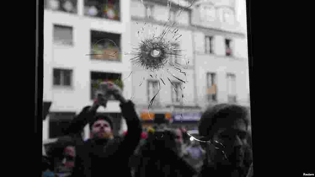 Des journalistes travaillent sur les lieux d'une des attaques, un restaurant parisien, le 14 novembre 2015.&nbsp;