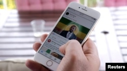 FILE - A man scrolls through his social media news feed for information about Ethiopian Prime Minister Abiy Ahmed's selection as winner of the Nobel Peace Prize in Addis Ababa, Oct. 11, 2019.