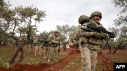 Turkish soldiers gather in the village of Qaminas, about 6 kilometers southeast of Idlib city in northwestern Syria, Feb. 10, 2020.