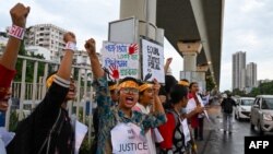 Health professionals and activists shout slogans and hold posters as they form a long human chain during a demonstration to condemn the rape and murder of a doctor, along a street in Kolkata on Sept. 3, 2024.