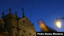 Seseorang berjalan di dekat sebuah gereja di pusat kota Lisbon, Portugal, 2 Desember 2021. Portugal mengatakan siap untuk menyelidiki kemungkinan terjadinya kasus pelecehan yang dilakukan terhadap anak-anak di bawah umur di dalam Gereja Katolik.(Foto: REUTERS/Pedro Nunes)