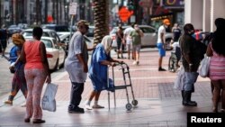 FILE - Evacuees from the Lake Charles area who were in the path of Hurricane Laura arrive to stay at a New Orleans Marriott, one of several hotels where the state of Louisiana requested that rooms be reserved for storm victims, Aug. 28, 2020.