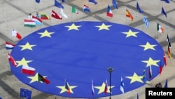 FILE - A large European Union flag lies at the center of Schuman Square outside European Commission headquarters in Brussels, Belgium, May 8, 2021. 