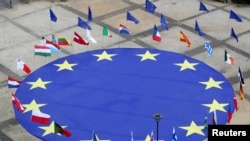 FILE - A large European Union flag lies at the center of Schuman Square outside European Commission headquarters in Brussels, Belgium, May 8, 2021. 