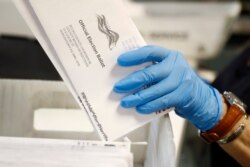FILE - A worker processes mail-in ballots at the Bucks County Board of Elections office prior to a primary election in Doylestown, Pennsylvania, May 27, 2020.