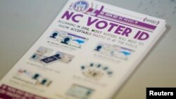 A pile of government pamphlets explaining North Carolina's controversial voter ID law sits on table at a polling station.