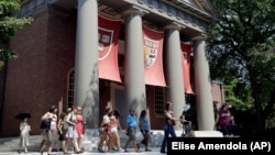FILE - People are led on a tour on the campus of Harvard University in Cambridge, Massachusetts. Refugees worldwide will be able to take more than 1,000 online university courses for free.