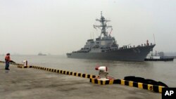 FILE - Chinese Navy personnel stand guard as guided missile destroyer USS Stethem arrives at the Shanghai International Passenger Quay for a scheduled port visit in Shanghai, China, Nov. 16, 2015. 