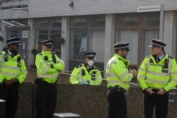 One out of five British police officers wears a 3M face mask outside St Thomas' Hospital, in London, where Prime Minister Boris Johnson remains as his coronavirus symptoms persist, April 9, 2020.