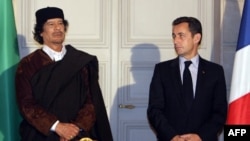 Le président français Nicolas Sarkozy et le leader libyen Mouammar Kadhafi posent lors de la signature de 10 milliards d'euros de contrats commerciaux, à Paris, le 10 décembre 2007.