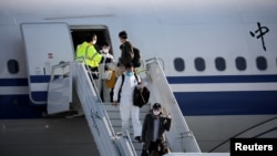 Members of an aid expedition in protective masks disembark from Air China plane carrying medical supplies donated by the Chinese government, in Athens, Greece, March 21, 2020.