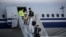 Members of an aid expedition in protective masks disembark from Air China plane carrying medical supplies donated by the Chinese government, in Athens, Greece, March 21, 2020.
