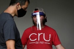 Volunteer and student Nathan Hsieh wears a face shield as he assists college students who begin moving in for the fall semester at N.C. State University in Raleigh, N.C., July 31, 2020.