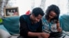 Getahun Fetana (L) and his wife Emebet Melaku (R), married taking advantage of a chance run-in during Timkat, the Ethiopian Orthodox celebration of epiphany, looks at photographs in their home in the city of Gondar, Ethiopia, January 18, 2020.