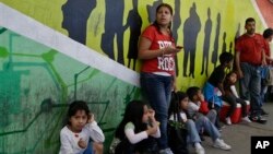 Sandra Ramirez stands with four of her children along the walkway to the United States to support members of the group Border Dreamers, Tijuana, Mexico, March 10, 2014.